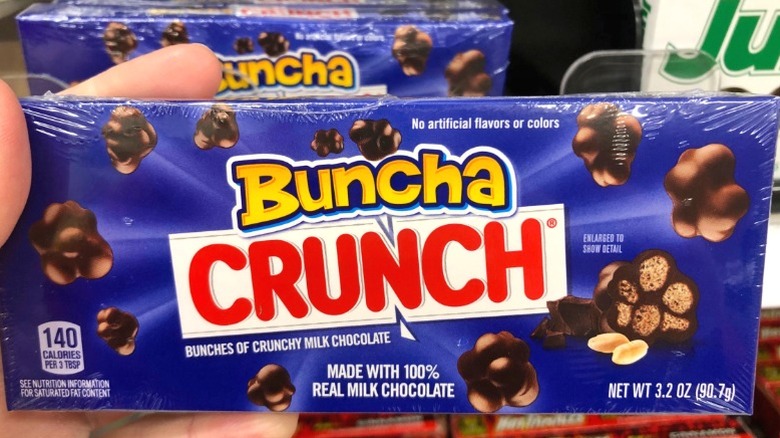 A hand holding a box of Buncha Crunch.