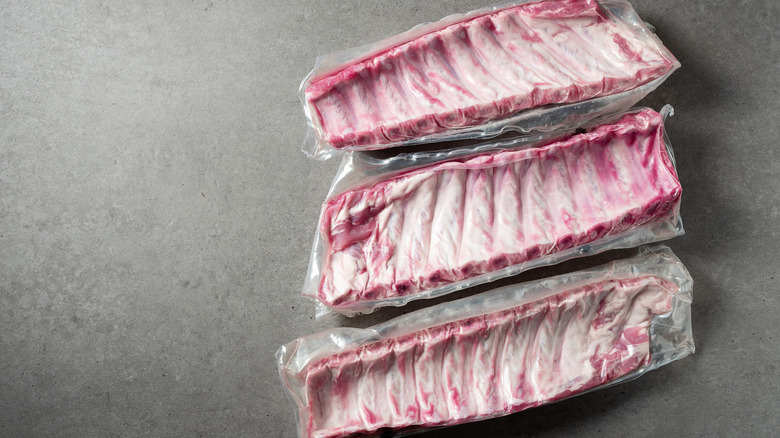 Three racks of pork ribs in vacuum-sealed packages