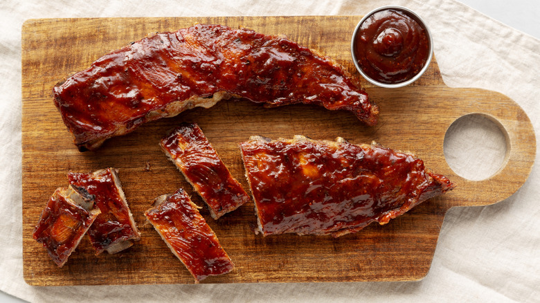 Top view of barbecue sauce-glazed pork ribs on wooden cutting board