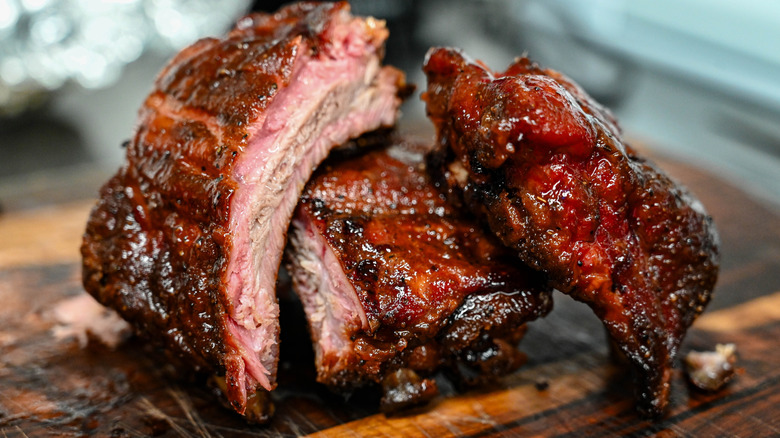 Stack of smoked pork ribs on wooden cutting board