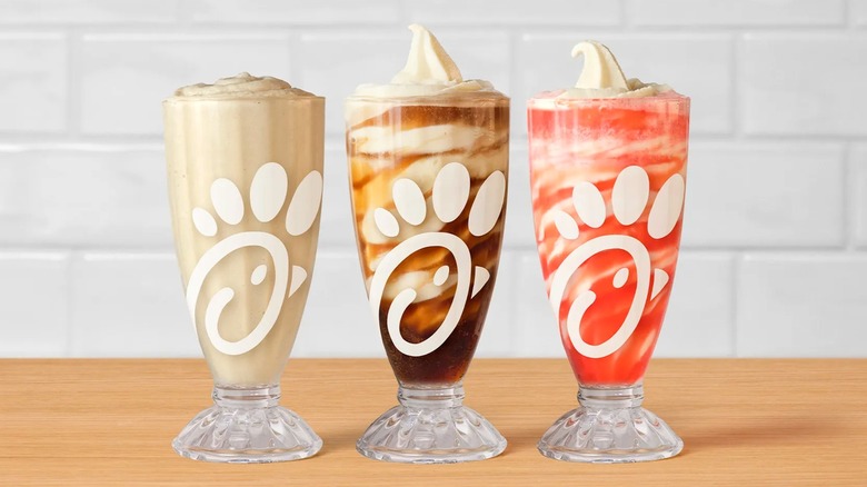 Chick-fil-A Frosted Sodas and Floats sitting on a wood table.