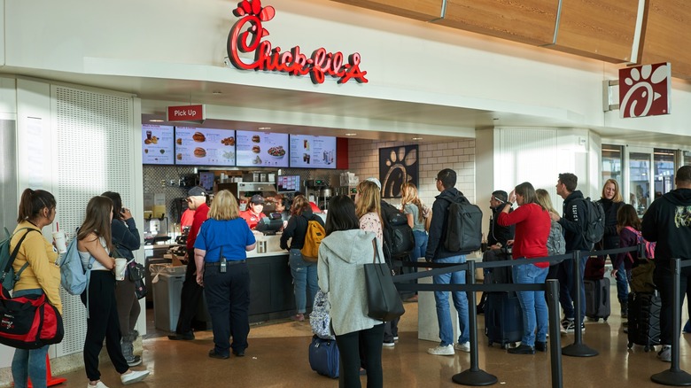 People waiting in line at Chick-fil-A in an airport.