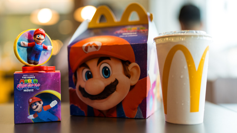 A Mcdonald's Happy Meal with Mario branding and a Mario Movie toy