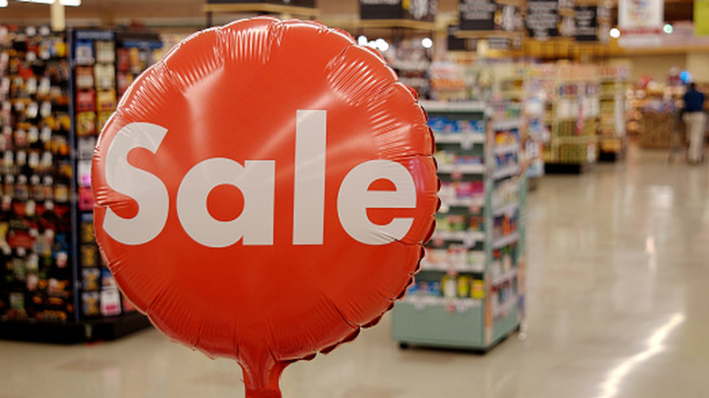 A balloon marked 'sale' in front of a grocery store aisle