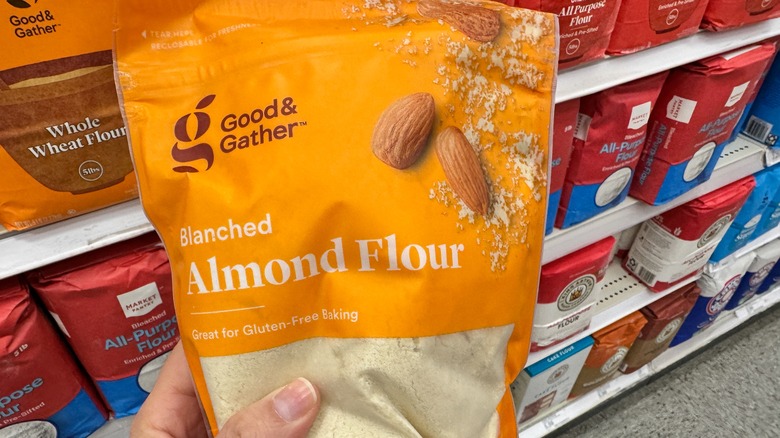 A hand holds a Good & Gather branded bag of almond flour