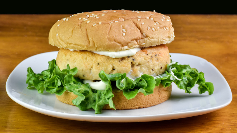 salmon burger on a bun with lettuce and mayonnaise