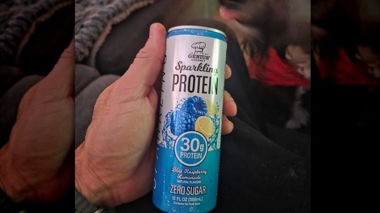 hand holding a can of Genius Gourmet Sparkling Protein