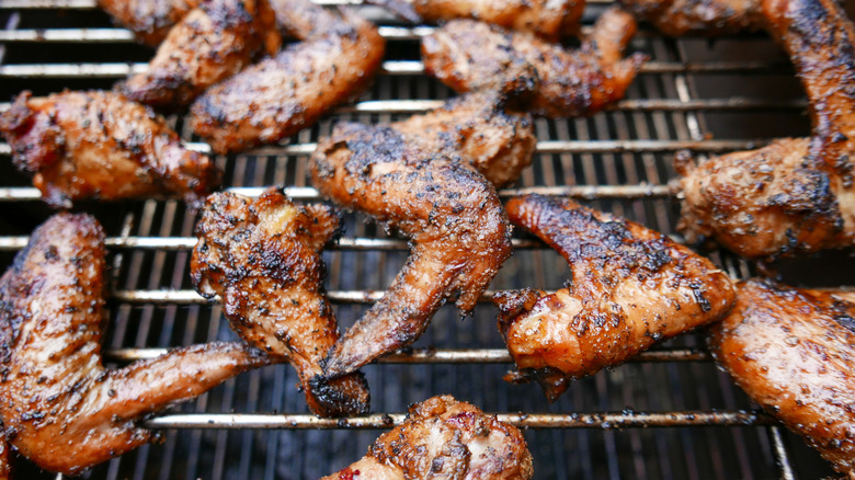Browned, crispy chicken wings cooking on a grill