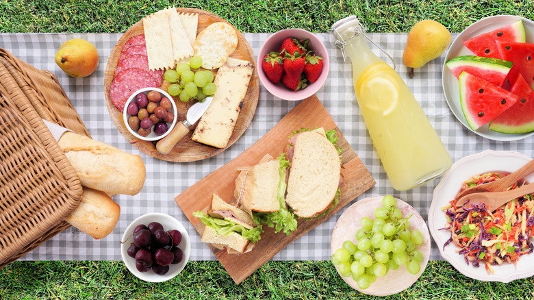 A picnic blanket with a selection of summer foods, shot from above
