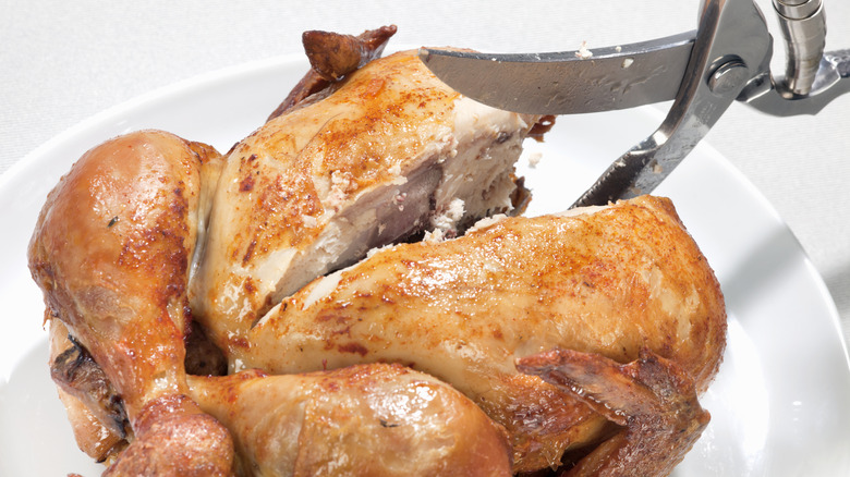 cutting a rotisserie chicken with curved kitchen shears