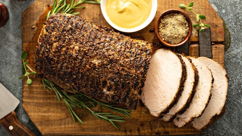 A roasted pork tenderloin with rosemary, mustard, and spices.