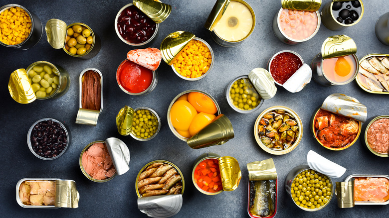 Various cans of food with their lids peeled back, shot from above