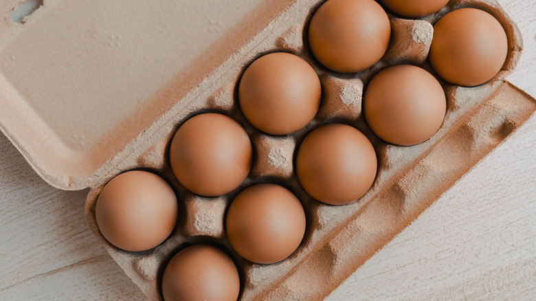 Fresh brown eggs in a carton, shot from above