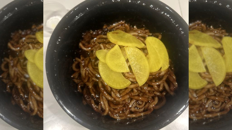 Jjajangmyeon with yellow radish on a tabletop