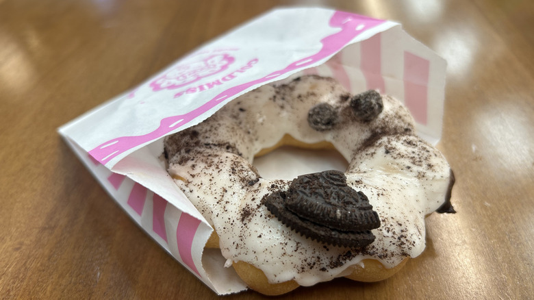 Cookies and cream mochi donut on a tabletop, in a wrapper