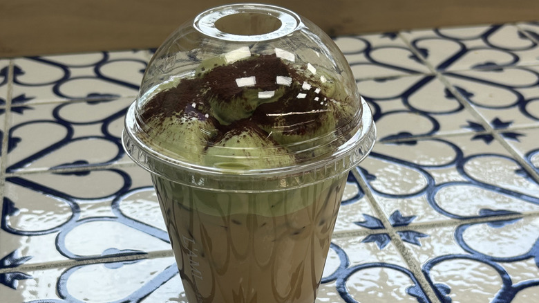 Matcha einspanner on a floral, tiled tabletop.