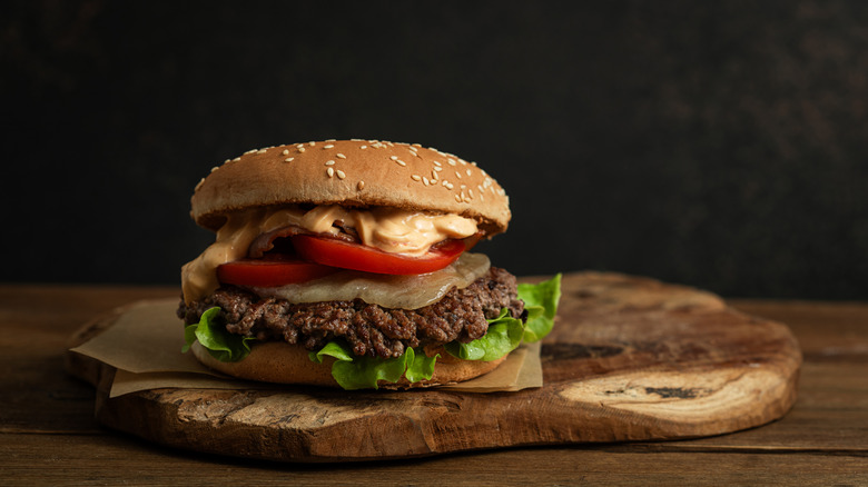 Large burger on wooden servign platter