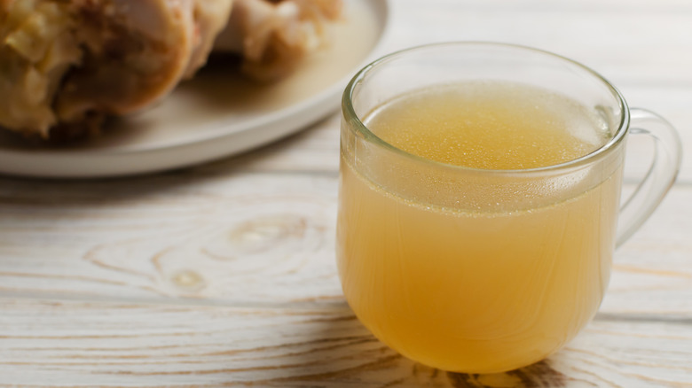 A cup of bone broth on a farmhouse table.