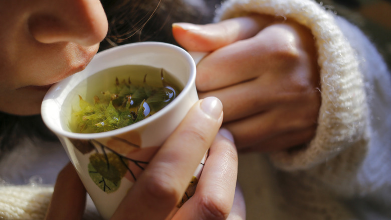A person sipping a cup of tea