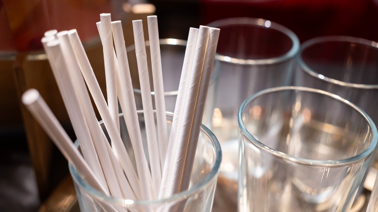 Paper straws in a tall glass up close.