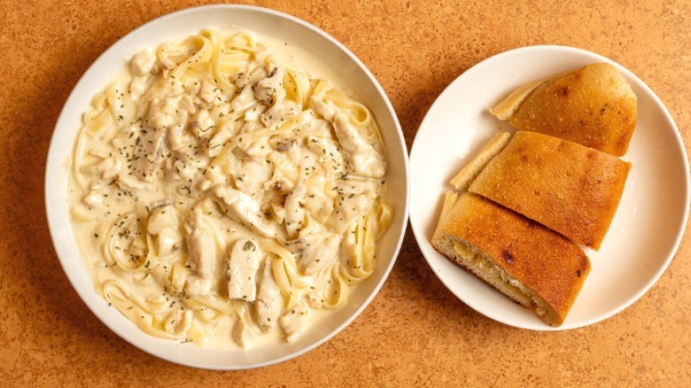 Fettuccine alfredo with a side of garlic bread.