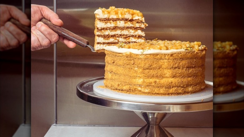 A slice of apple honey cake from Hani's is lifted with a cake knife