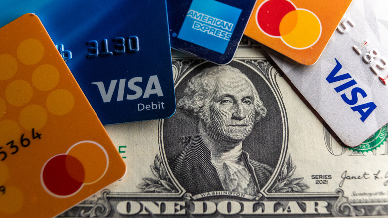 Close-up of various Visa credit and debit cards and a dollar bill