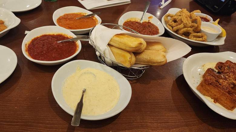 Breadsticks and assorted appetizers with dipping sauces at Olive Garden.