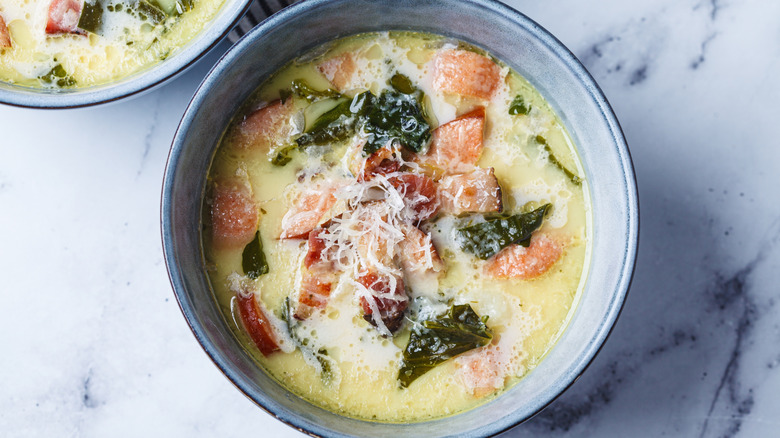 Multiple bowls of zuppa Toscana on a granite countertop.