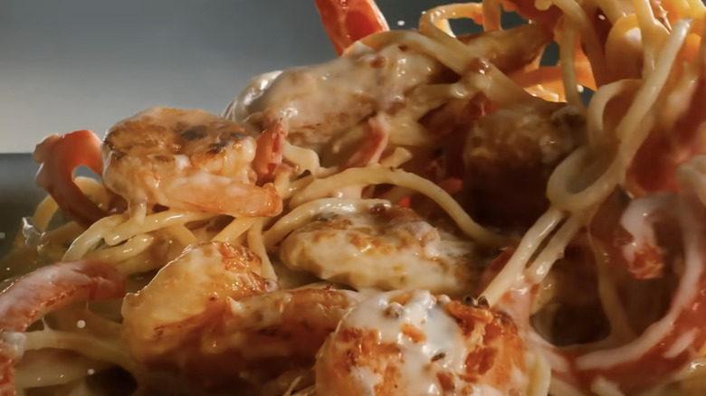 Olive Garden shrimp and pasta being tossed in a pan.