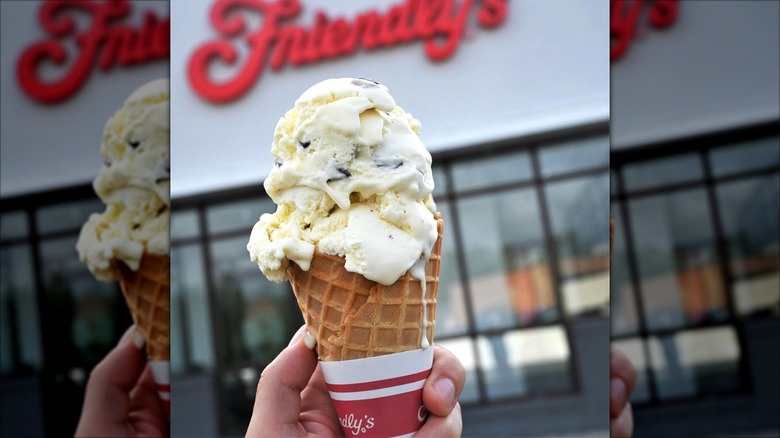 Person holding ice cream cone in front of Friendly's restaurant