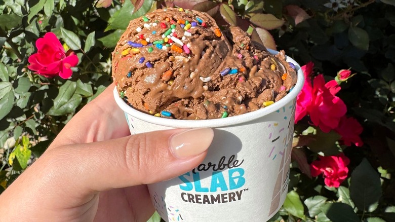 Person holding cup of ice cream from Marble Slab Creamery