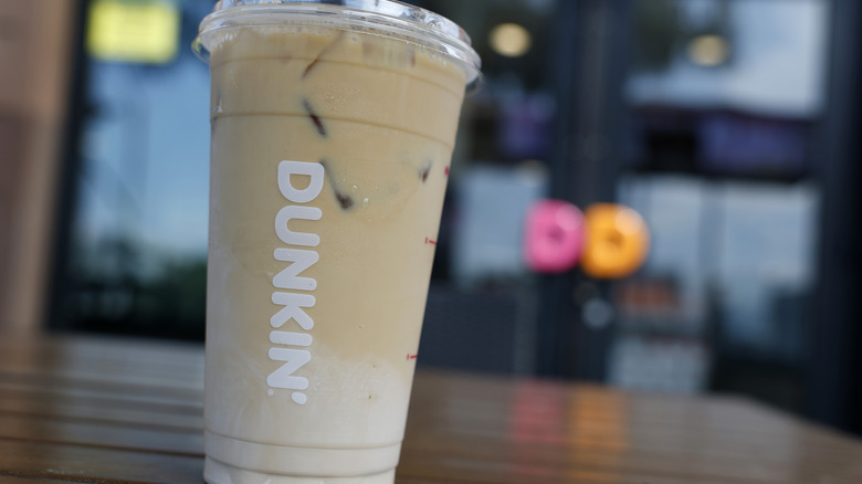 A creamy Dunkin' drink sitting on a table.