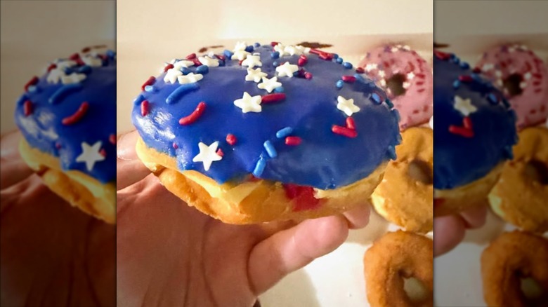 Someone holding a Rocket Pop Donut from Dunkin' in their hand.