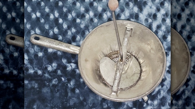 A vintage hand-crank food mill