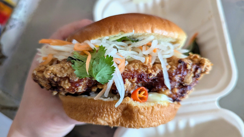 hand holding cambodian fried chicken sandwich