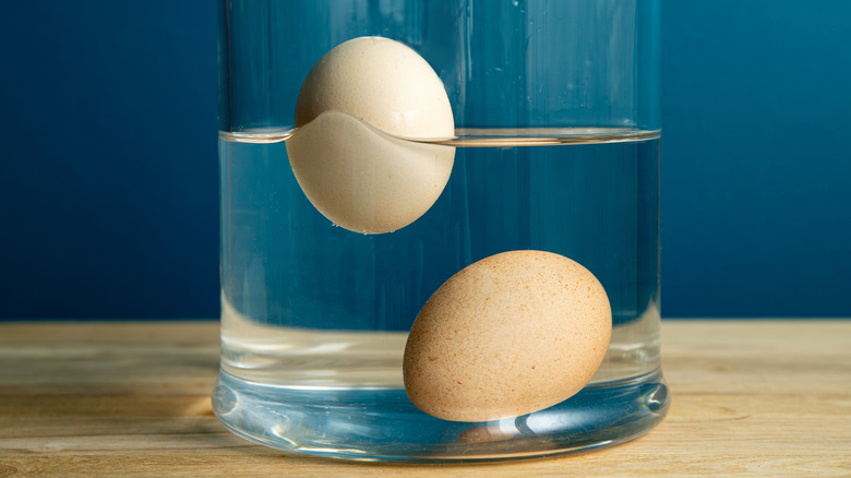 Two whole eggs in a glass of water