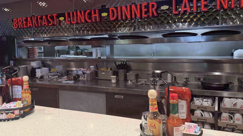 The interior of a Denny's, including signs for breakfast, lunch, and dinner