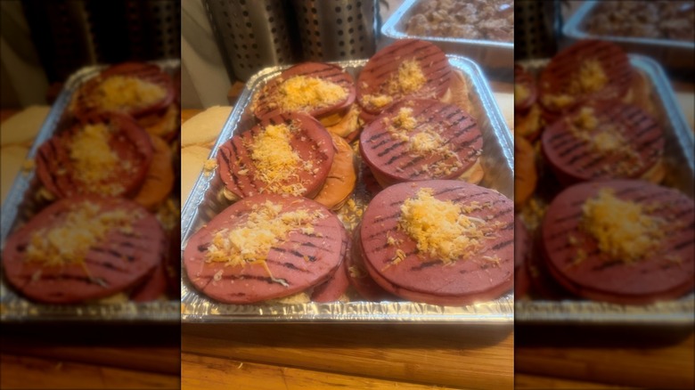 Grilled bologna slices sitting in a foil pan.
