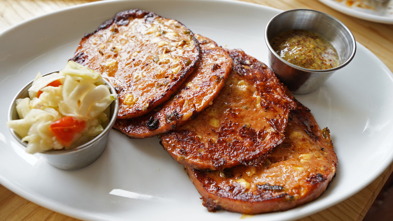 Fried slices of bologna sitting on a white plate