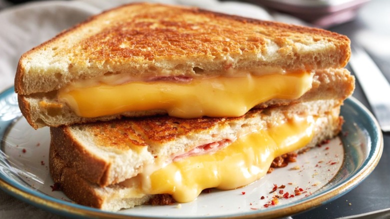 A grilled cheese sandwich on a blue-and-white plate, sliced diagonally.