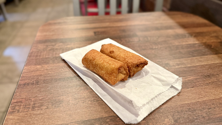 Two Arby's Peach Cobbler Rolls on a wrapper on table