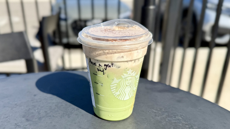 Starbucks Iced Dubai Chocolate Matcha on a table in an outdoor seating area
