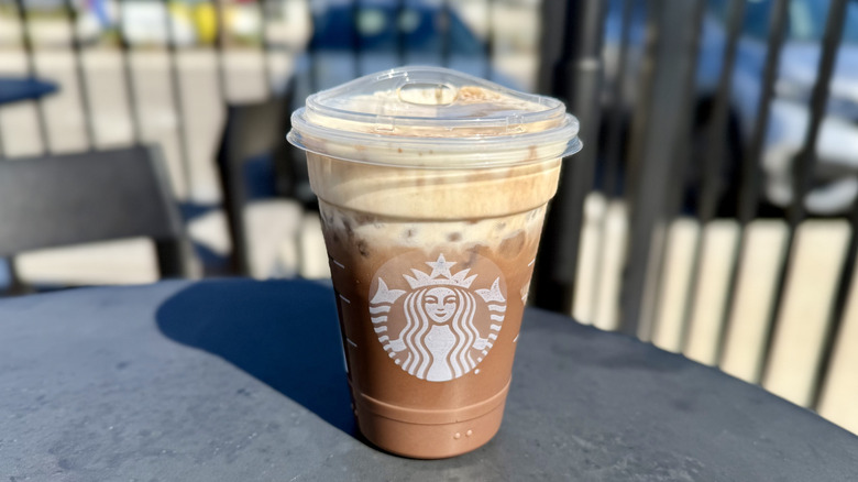 Starbucks Iced Dubai Chocolate Mocha on a table in outdoor seating area