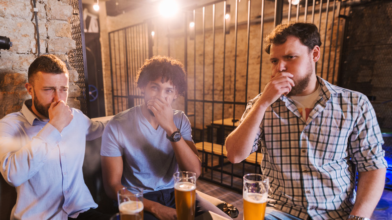 Three men at a brewery, disgusted by something