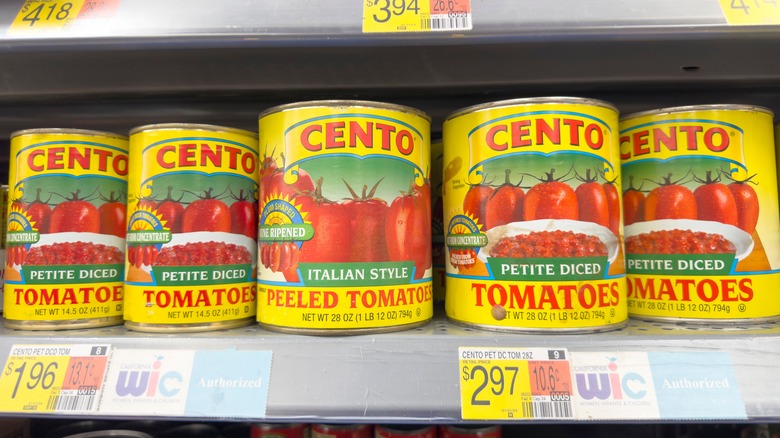 Cans of Cento peeled tomatoes on grocery store shelf