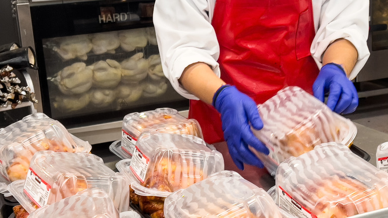 A Costco employee prepares rotisserie chickens
