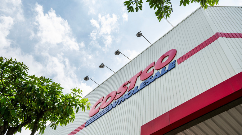 Signage on a Costco store, with trees and a blue sky