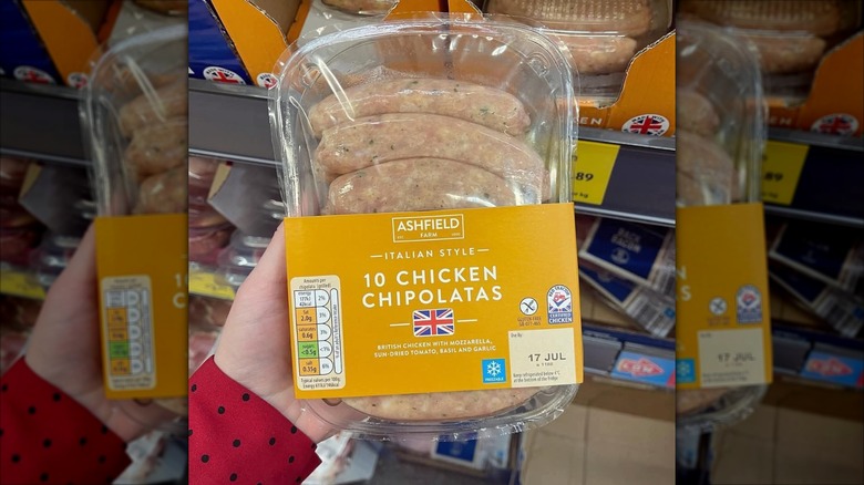 Hand holding packet of chicken chipolatas