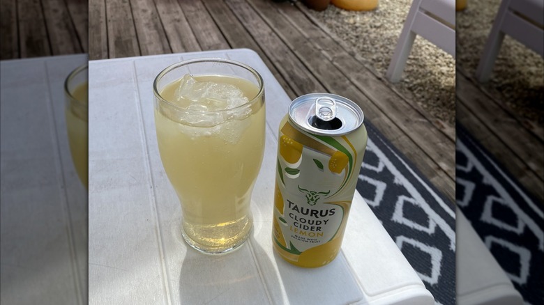 Glass and can of Taurus Cloudy Cider Lemon